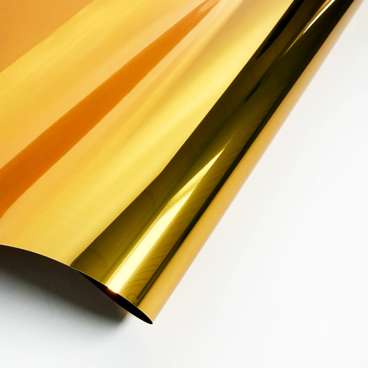 Curled sheet of gold mirror-finish printable metallic film.